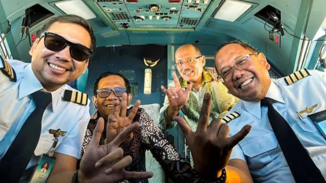Mahfud MD berpose dalam kokpit bersama Pilot dan memamerkan 3 jari.
