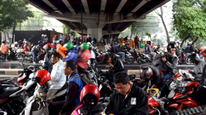 Para pengendara motor berteduh di kolong jembatan