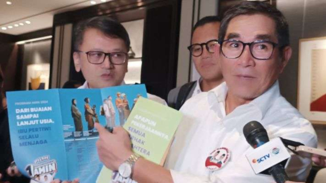 Ketua Dewan Pakar Tim Nasional Pemenangan Anies Baswedan-Muhaimin Iskandar (Amin), Hamdan Zoelva, menunjukkan program capres-cawapres nomor urut 1 di Jakarta, Rabu, 29 November 2023.