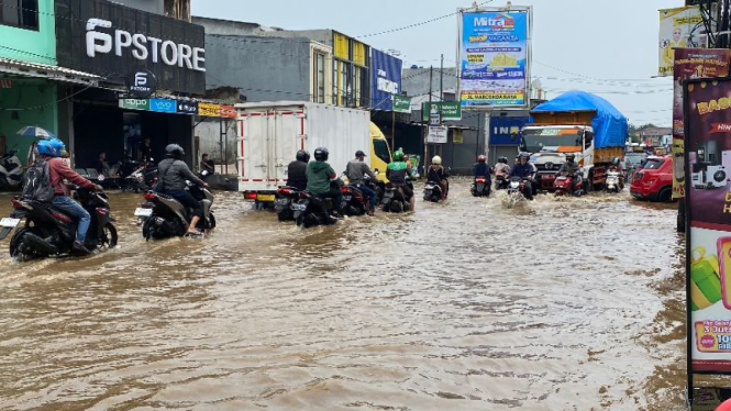 Air Kali Cabang Tengah meluap ke jalan.