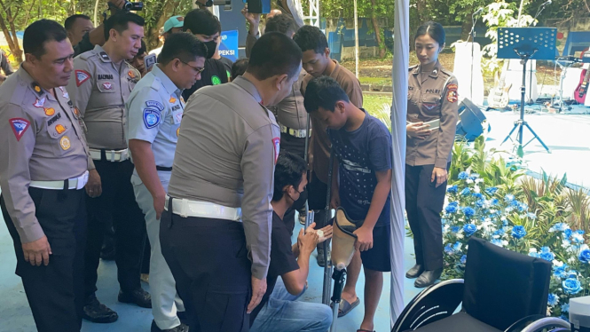 Korlantas Polri saat membantu penyandang disabilitas
