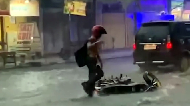 Pengendara motor Honda CB jatuh saat banjir