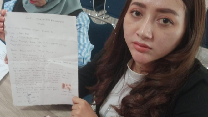 Kades Kedungkumpul Angely Emitasari saat melapor ke Polres Lamongan. (Imron Saputra/Viva Jatim)