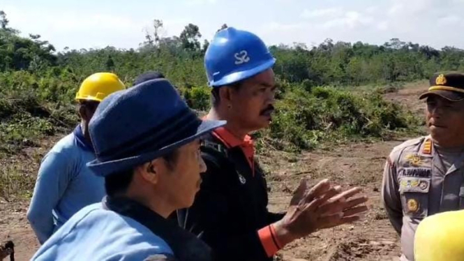 Para Petani sawit di Kaltim Menjelaskan Lokasi Lahan Mereka pada Aparat yang Berjaga.