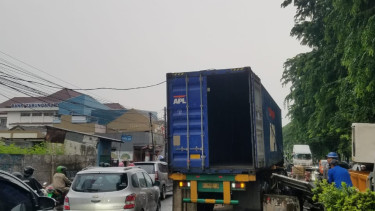 Truk peti kemas hantam pembatas jalan