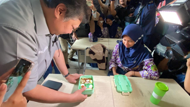 Menko Perekonomian Airlangga Hartarto saat melakukan simulasi makan siang gratis di SMPN 2 Curug.