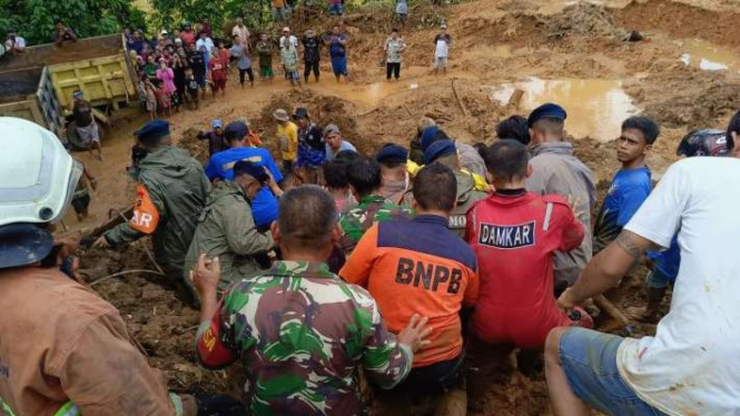 Tim gabungan bersama warga saat mengevakuasi jasad seorang korban banjir-tanah l