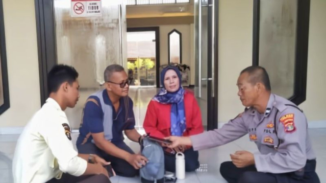 Aiptu Supriyanto (kanan) saat mengembalikan tas pemudik.