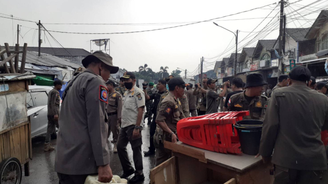 Petugas mengangkut barang milik pedagang pasar kutabumi
