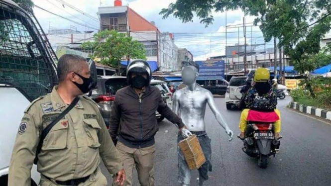 Dinsos Makassar razia dengan mengamankan manusia silver yang mengemis di Jalan Kota Makassar. 