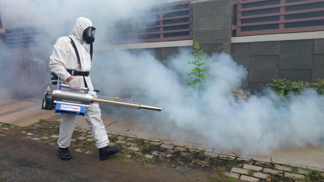 Petugas melakukan fogging atau pengasapan untuk mencegah penyebaran penyakit DBD
