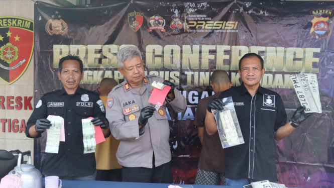 Petugas Polresta Tangerang dan Polsek Tigaraksa, menunjukkan barang bukti STNK palsu 