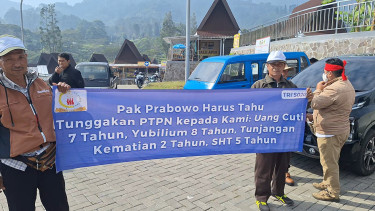 Salah seorang pensiunan PTPN VIII membawa sepanduk aspirasi. VIVA/Muhammad AR