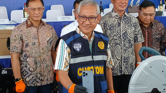Dirjen Bea dan Cukai, Askolani saat menunjukkan barang hasil penegahan iPhone 16 untuk dimusnahkan dengan cara dipotong