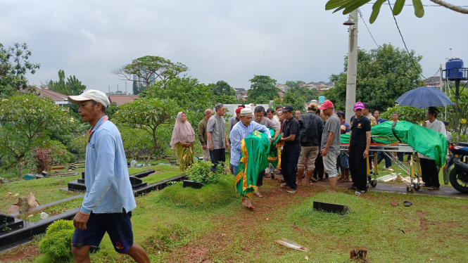 Proses pemakaman salah satu korban dalam kasus meninggalnya satu keluarga diduga akibat pinjol