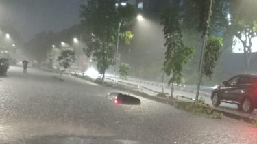 Sebuah mobil yang terperosok saluran air, akibat luapan air saat banjir melanda, Selasa 29 Januari 2025 malam. 