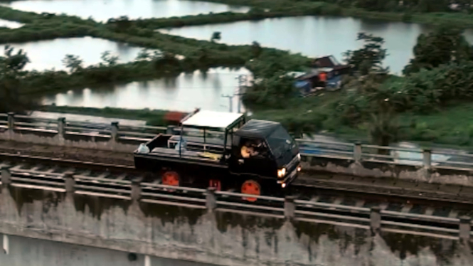 Mitsubishi Colt L300 lewat rel kereta