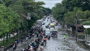 Genangan air yang cukup tinggi membuat arus lalu lintas terganggu, menyebabkan kemacetan panjang di ruas jalan tersebut.