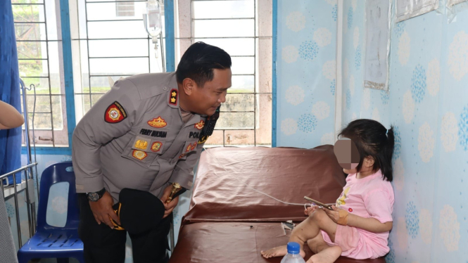Kapolres AKBP. Ferry Mulyana Sunarya saat bertemu dengan bocah 10 tahun yang viral diduga dianiaya.(dok Polres Nias Selatan)