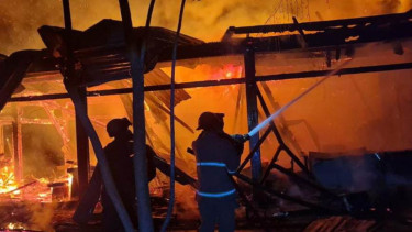 Petugas memadamkan api di Mahkota Cafe Love Garden Lamongan. (Foto: Imron Saputra/VIVA Jatim)