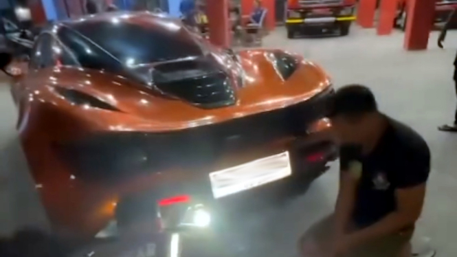 Petugas Damkar membantu pemilik supercar McLaren