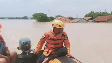 Petugas memantau warga yang belum dievakuasi saat banjir di Karawang