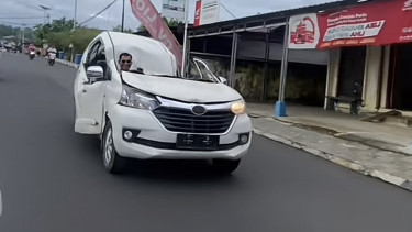 Seorang mengemudikan mobil yang rusak parah