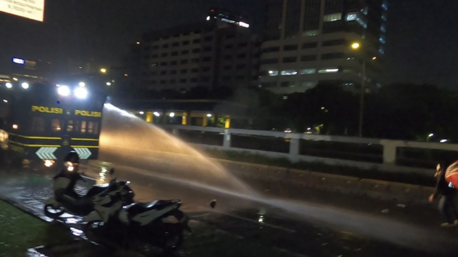 Suara petasan meledak di tengah massa, sementara polisi mengerahkan mobil pengurai massa dan water cannon untuk membubarkan demonstran.