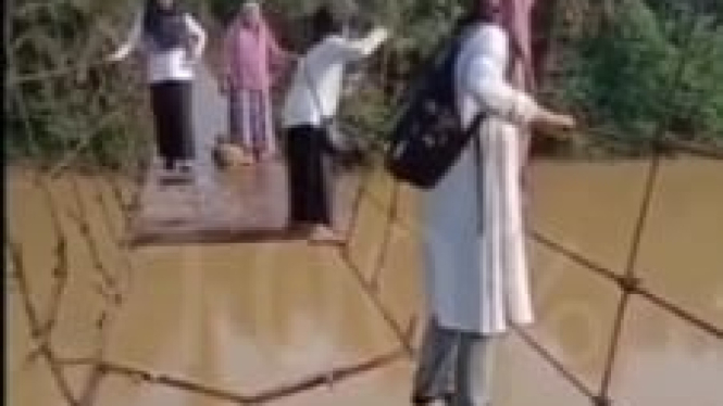 Foto : Para Guru Bergelantungan di Jembatan Gantung Saat Pergi ke Sekolah di Desa Limbur Merangin, Kecamatan Pamenang, Kabupaten Merangin,Jambi 