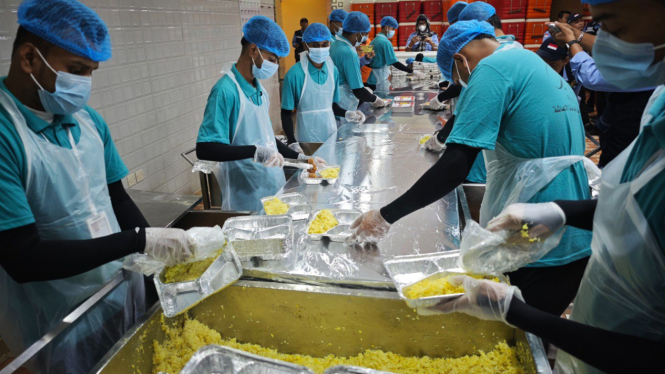 Pekerja mengemas makanan di dapur Raghaeb Catering, Makkah, Arab Saudi