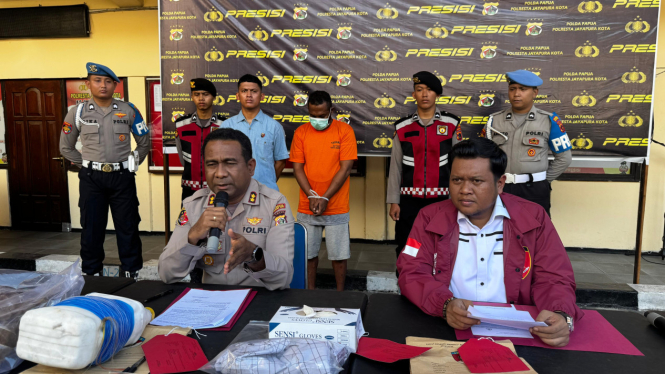 Polisi saat menunjukkan pelaku pembunuhan anak di Papua