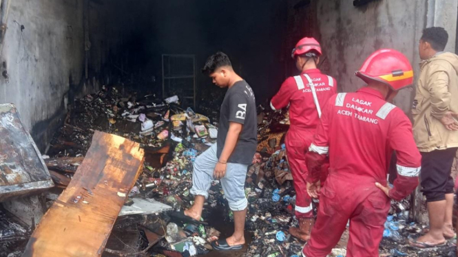 Petugas damkar memeriksa ruko usai kebakaran di Aceh Tamiang. (ist)