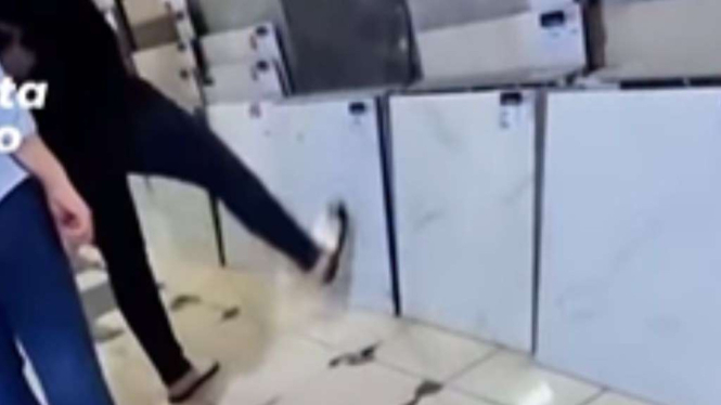 Pembeli menunjuk keramik dengan kaki.