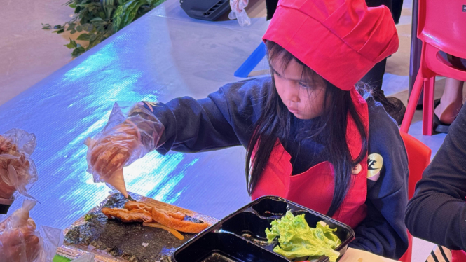 Anak belajar membuat sushi.