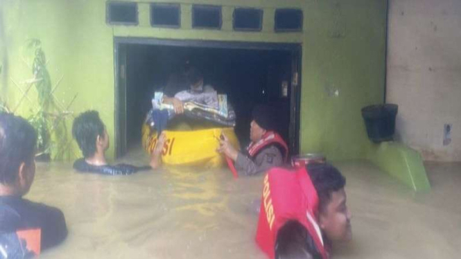 Petugas Ditsamapta Polda Metro Jaya mengevakuasi warga yang mengalami banjir.