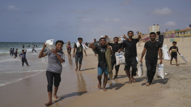 Warga Palestina mengambil bantuan yang dijatuhkan di pantai Zawaida, Jalur Gaza 