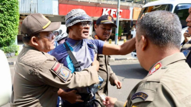 Petugas menangkap seorang juru parkir liar di Jakarta, Kamis 31 Juli 2025