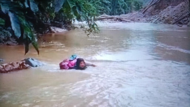 Bidan Dona Lubis (46) saat mengarungi derasnya Sungai Batang Pasaman