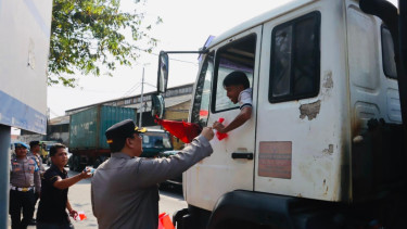 Kapolres Priok AKBP Martuasah Tobing membagikan bendera merah putih