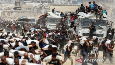 Sejumlah warga membawa kantong tepung dari truk bantuan kemanusiaan di Gaza